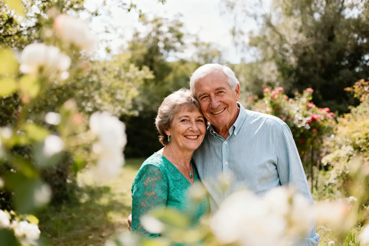 Un couple souriant dans un jardin célèbre ses noces d'émeraude en plein air